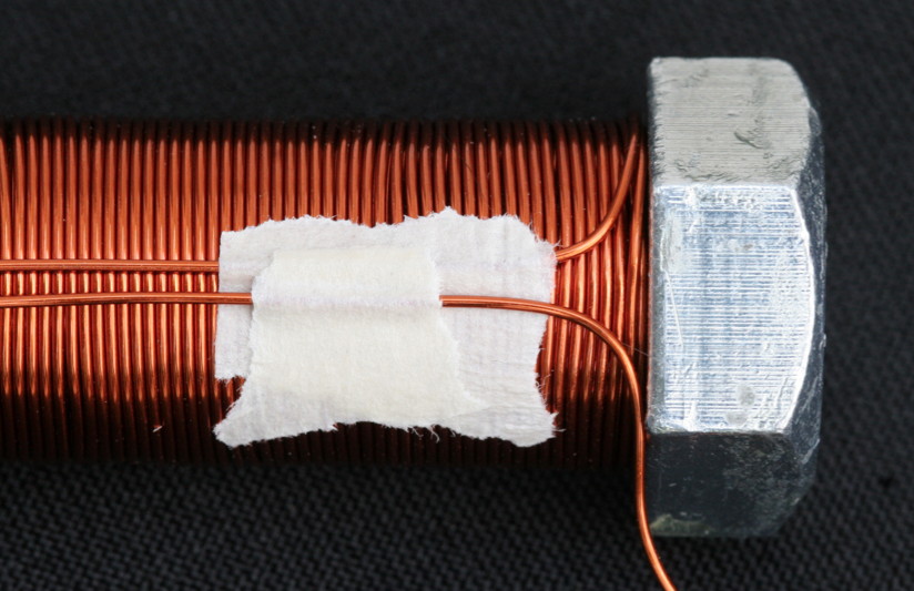 Continue wrapping the fourth layer as if the center tap never happened. Use small bits of tape to hold the center tap wires in position.